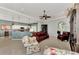 Inviting living room featuring a ceiling fan, comfortable seating, and an open view of the kitchen and dining area at 13335 Golf Pointe Dr, Port Charlotte, FL 33953