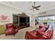 Spacious living room featuring comfortable seating, a ceiling fan, tile flooring, and a view of the backyard at 13335 Golf Pointe Dr, Port Charlotte, FL 33953