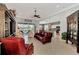 Open-concept living room boasts tile floors, a ceiling fan, and views of the backyard and kitchen at 13335 Golf Pointe Dr, Port Charlotte, FL 33953