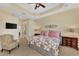 Spacious main bedroom featuring an ensuite bathroom, a ceiling fan, and a large decorative wall decor at 13335 Golf Pointe Dr, Port Charlotte, FL 33953