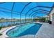 Beautiful in-ground pool with a screened enclosure overlooking a serene lake at 13335 Golf Pointe Dr, Port Charlotte, FL 33953