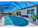 Screened-in pool area offers a private oasis with a sparkling pool and ample patio space for relaxation at 13335 Golf Pointe Dr, Port Charlotte, FL 33953