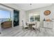 Bright dining area with wood floors, modern lighting fixture, and sliding doors to balcony overlooking water at 1400 Beach Rd # 2, Englewood, FL 34223