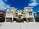 Inviting stilt home with a yellow exterior, palm trees, and ample parking underneath at 1400 Beach Rd # 2, Englewood, FL 34223