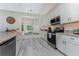 Well-lit kitchen featuring white cabinets, granite countertops, and a window seat at 1400 Beach Rd # 2, Englewood, FL 34223