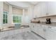 Kitchen window seat features natural light, view of backyard, granite counters and white cabinets at 1400 Beach Rd # 2, Englewood, FL 34223
