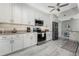 Bright kitchen with stainless steel appliances, white cabinets, and tile backsplash at 1400 Beach Rd # 2, Englewood, FL 34223