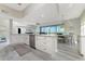 Open concept living room with kitchen island, dining area, and sliding doors to the balcony at 1400 Beach Rd # 2, Englewood, FL 34223