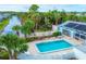 Aerial view of a pool area with trees and waterway views, offering a tranquil and secluded setting at 14454 Worthwhile Rd, Port Charlotte, FL 33953