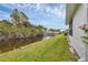Scenic backyard featuring a peaceful canal, complemented by tropical landscaping and a walking bridge at 14454 Worthwhile Rd, Port Charlotte, FL 33953