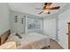 Serene bedroom featuring a comfortable bed, a ceiling fan, and ample natural light from the window at 14454 Worthwhile Rd, Port Charlotte, FL 33953