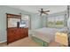 Comfortable bedroom with large windows, a dresser with a mirror, and a ceiling fan at 14454 Worthwhile Rd, Port Charlotte, FL 33953