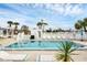 Community pool with clear blue water, surrounded by lounge chairs and umbrellas, perfect for relaxation at 14454 Worthwhile Rd, Port Charlotte, FL 33953