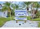 Community sign surrounded by palm trees and landscaping, welcomes residents to this deed-restricted neighborhood at 14454 Worthwhile Rd, Port Charlotte, FL 33953