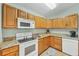 Charming kitchen featuring ample cabinet space, granite counters, and modern white appliances at 14454 Worthwhile Rd, Port Charlotte, FL 33953