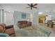 Cozy living room featuring a sofa, ceiling fan, and adjacent kitchen and entryway at 14454 Worthwhile Rd, Port Charlotte, FL 33953