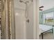 Updated shower featuring a curtain and an adjustable shower head leading to the bedroom at 14454 Worthwhile Rd, Port Charlotte, FL 33953