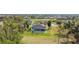 View of backyard and lanai pool area with lush landscaping and beautiful screened-in lanai at 16 Pine Valley Ct, Rotonda West, FL 33947