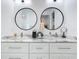 Modern bathroom with double vanity, marble countertop, and round mirrors at 16 Pine Valley Ct, Rotonda West, FL 33947