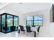 Elegant dining room with marble floors, modern light fixture, and views of the screened in pool at 16 Pine Valley Ct, Rotonda West, FL 33947