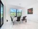 Elegant dining room with marble floors, modern light fixture, and views of the landscaped yard at 16 Pine Valley Ct, Rotonda West, FL 33947