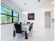 Bright dining room with marble floors, modern light fixture, and views of the landscaped yard at 16 Pine Valley Ct, Rotonda West, FL 33947