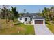 Beautiful single-Gathering home with a well-maintained lawn, a paver driveway, and a two-car garage at 16 Pine Valley Ct, Rotonda West, FL 33947