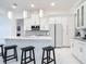 Modern kitchen with white cabinets, marble counters, island with seating, and stainless steel appliances at 16 Pine Valley Ct, Rotonda West, FL 33947