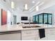 Modern kitchen featuring a large island, stainless steel sink, and views of the living area at 16 Pine Valley Ct, Rotonda West, FL 33947