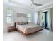 Bright main bedroom with a platform bed, ensuite, two windows, and sliding glass doors to balcony at 16 Pine Valley Ct, Rotonda West, FL 33947