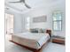 Bright main bedroom with a platform bed, ensuite, two windows, and a decorative art panel at 16 Pine Valley Ct, Rotonda West, FL 33947