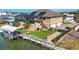 Aerial view of home with a boat dock, lift, canal, pool, screened-in lanai, and three-car garage at 1953 Georgia Ave, Englewood, FL 34224