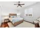 Bedroom with hardwood floors, a ceiling fan, wood-framed bed, and plantation shutters at 1953 Georgia Ave, Englewood, FL 34224