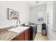 Well-lit laundry room featuring modern washer and dryer, granite countertops, and a convenient water dispenser at 1953 Georgia Ave, Englewood, FL 34224