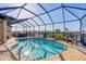 Inviting pool area with a screened enclosure, hot tub, and patio seating with relaxing neighborhood views at 1953 Georgia Ave, Englewood, FL 34224