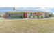 Inviting single-story home with a neatly kept lawn, colorful entryway, and decorative landscaping at 2140 Carnac St, Port Charlotte, FL 33952