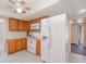 Kitchen features oak cabinets, white appliances, ceiling fan, and tile floors at 2140 Carnac St, Port Charlotte, FL 33952