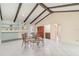 Spacious living room featuring vaulted ceilings with beams, tile floors, and dining area at 2140 Carnac St, Port Charlotte, FL 33952