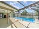 View of the screened-in pool with a deck, backyard and a black barbeque grill at 2140 Carnac St, Port Charlotte, FL 33952