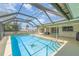 A relaxing pool area features a full screen enclosure, barbeque, and the backyard is ideal for outdoor living at 2140 Carnac St, Port Charlotte, FL 33952