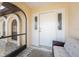 Welcoming front porch featuring decorative windows, a cozy bench, and a secure screen door, perfect for relaxation at 23347 Lehigh Ave, Port Charlotte, FL 33954