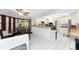 Bright kitchen features white cabinetry and a breakfast bar, located adjacent to the dining and screened-in patio at 23347 Lehigh Ave, Port Charlotte, FL 33954