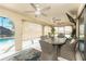 Enclosed patio area featuring a dining table and chairs, ceiling fans, and scenic views of the backyard pool at 23347 Lehigh Ave, Port Charlotte, FL 33954