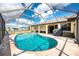 Inviting in-ground pool with a screened enclosure and surrounding patio at 23347 Lehigh Ave, Port Charlotte, FL 33954