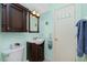 Bathroom features dark wood vanity, toilet, mirror, and a door with towel hooks at 2450 N Beach Rd # 231, Englewood, FL 34223