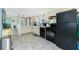 Bright kitchen with tile floors, black appliances, and plenty of counter space at 2450 N Beach Rd # 231, Englewood, FL 34223