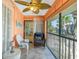 Relaxing porch features screened windows, comfortable seating, and bright peach walls at 2450 N Beach Rd # 231, Englewood, FL 34223