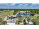 Waterfront home showcasing mature palms, circular drive, solar panels, and screened in ground pool at 24805 Nova Ln, Punta Gorda, FL 33980