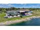Aerial view showcases a waterfront home with a screened pool and deck, set amidst lush landscaping at 24805 Nova Ln, Punta Gorda, FL 33980