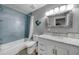 Bathroom with blue tiled shower/bath combo, decorative mirror and marble topped vanity at 24805 Nova Ln, Punta Gorda, FL 33980